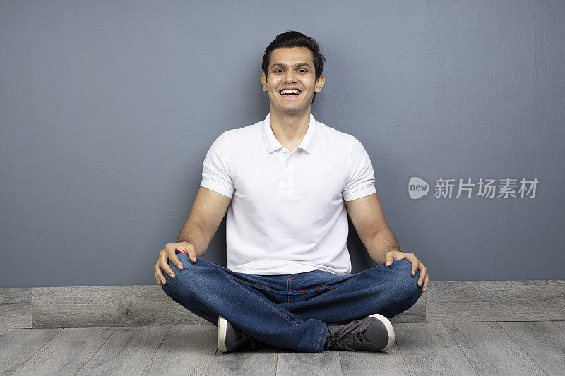 男人盘腿坐在地板上的stock photo